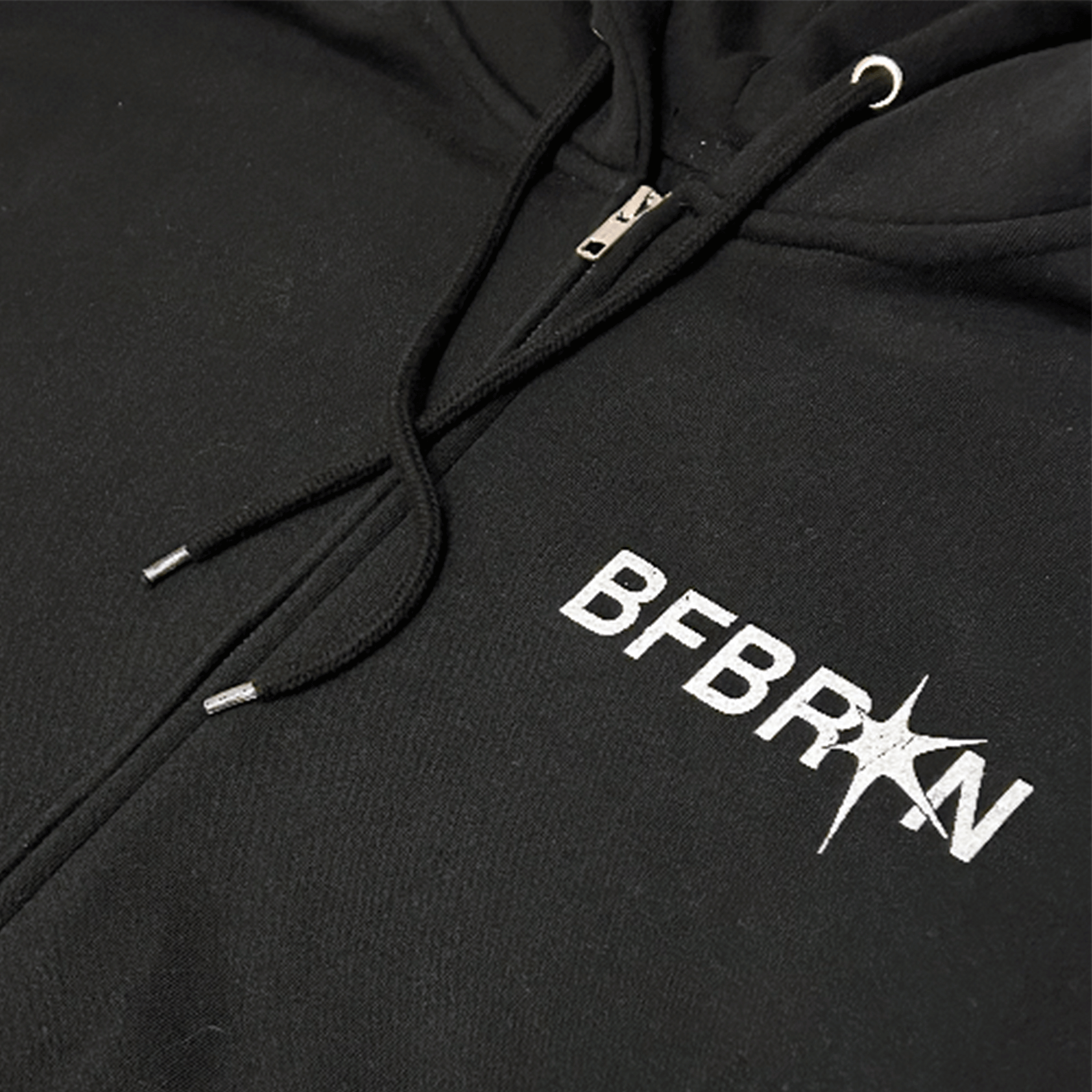 Close-up of the Prosper Zip-Up Hoodie (Black) featuring BFBRKN logo on a dark fabric background.